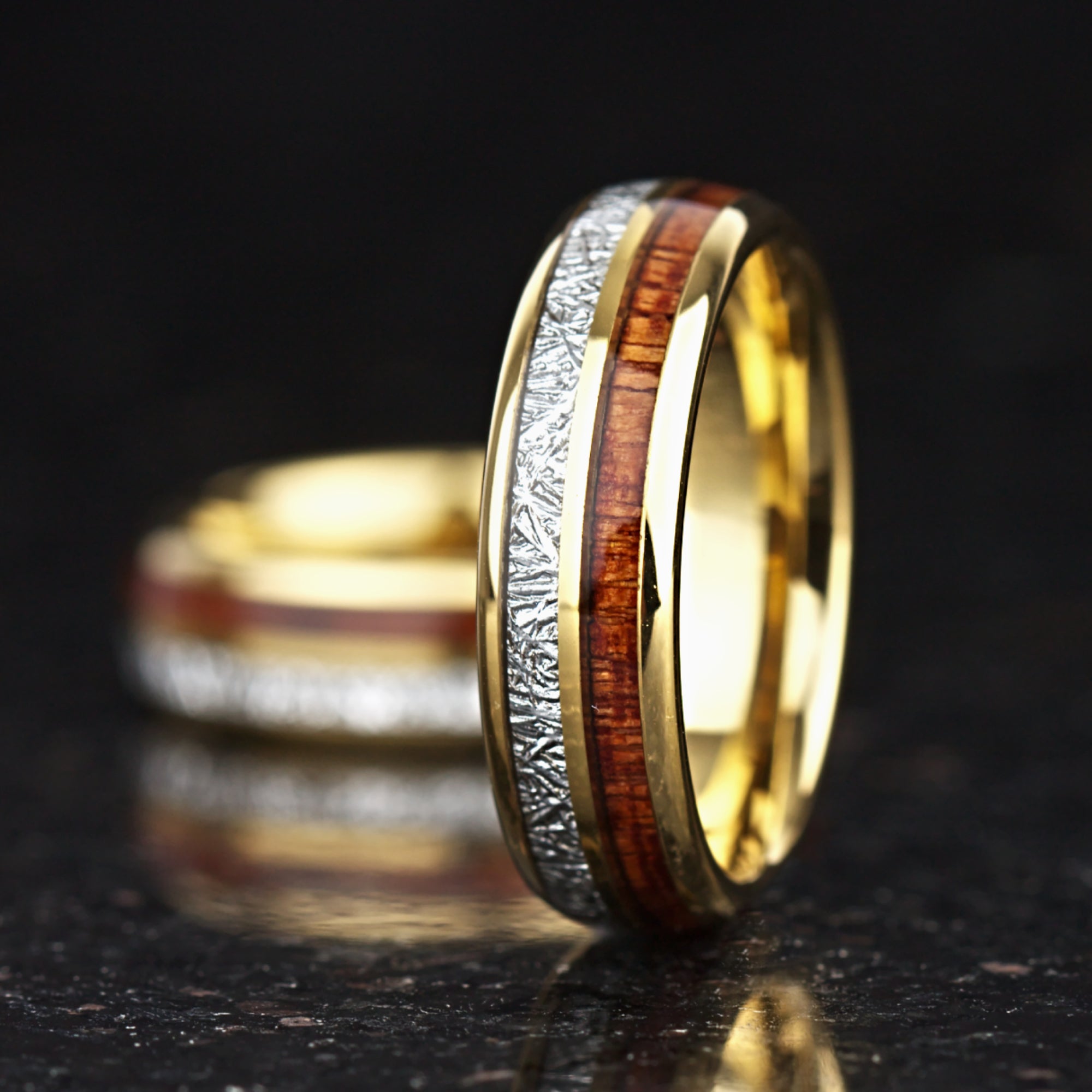 Gold tungsten wood rings with meteorite style inlay close up