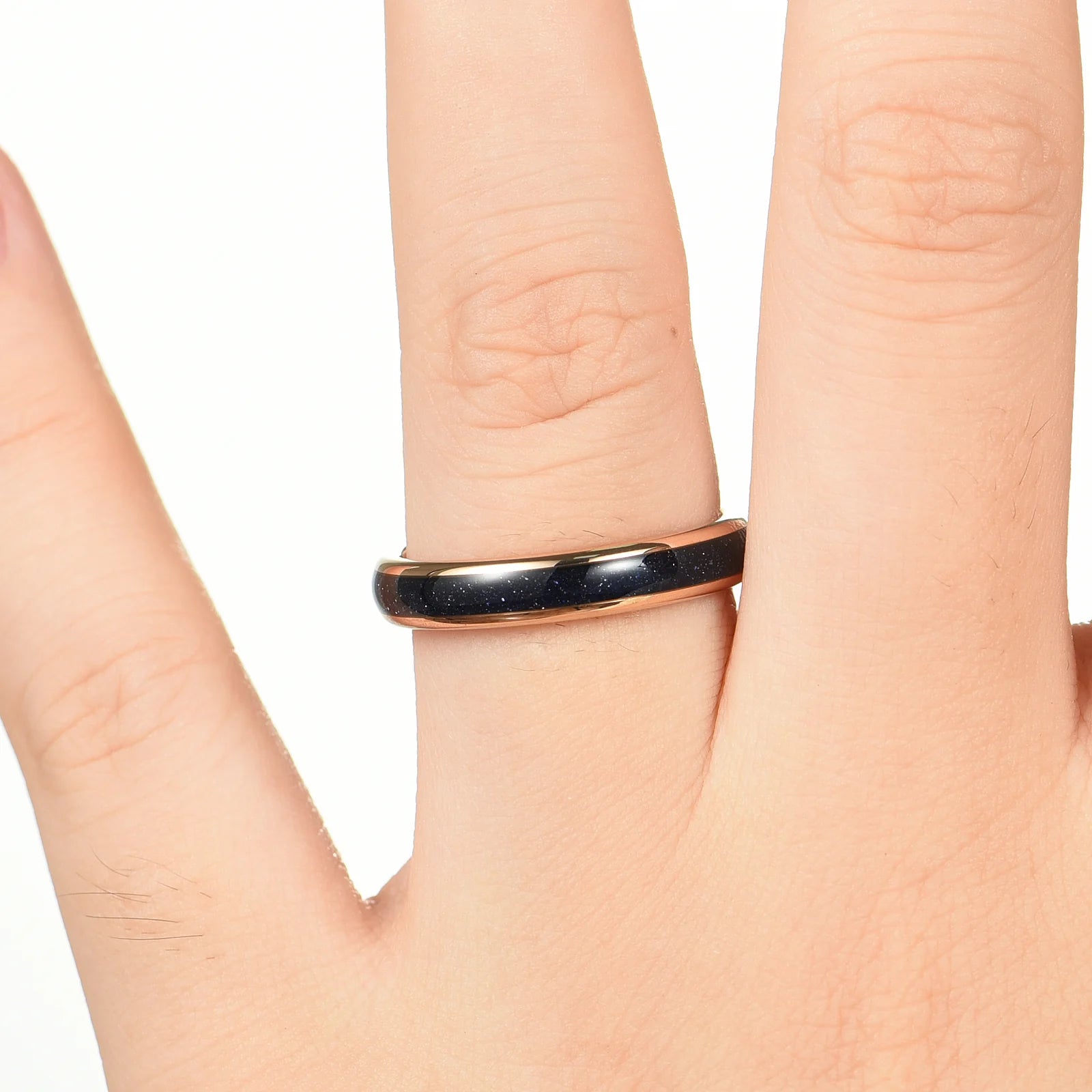 Rose gold commitment ring worn on female hand with blue sandstone and polished band